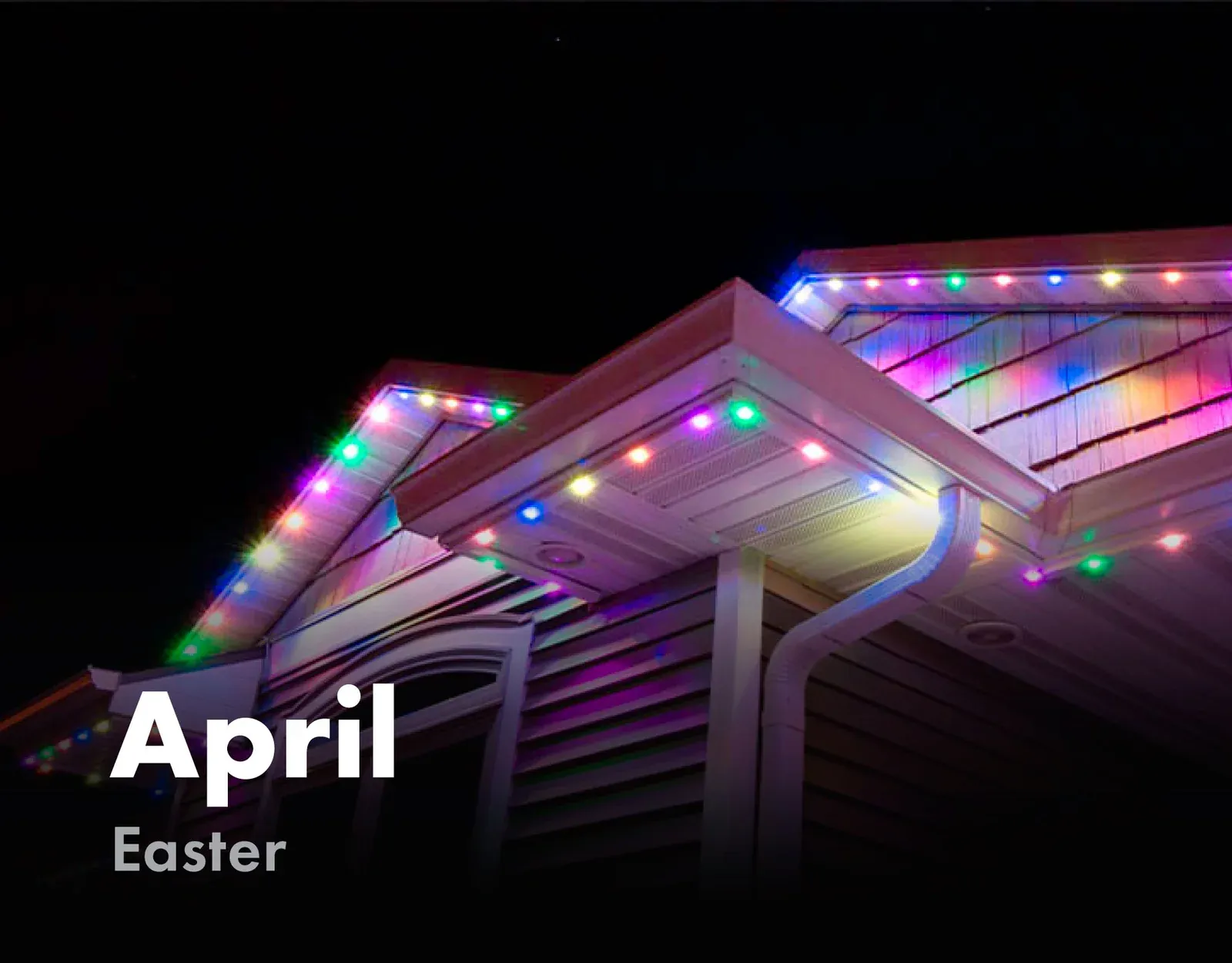 Home roofline lit in pastel colors for Easter in April
