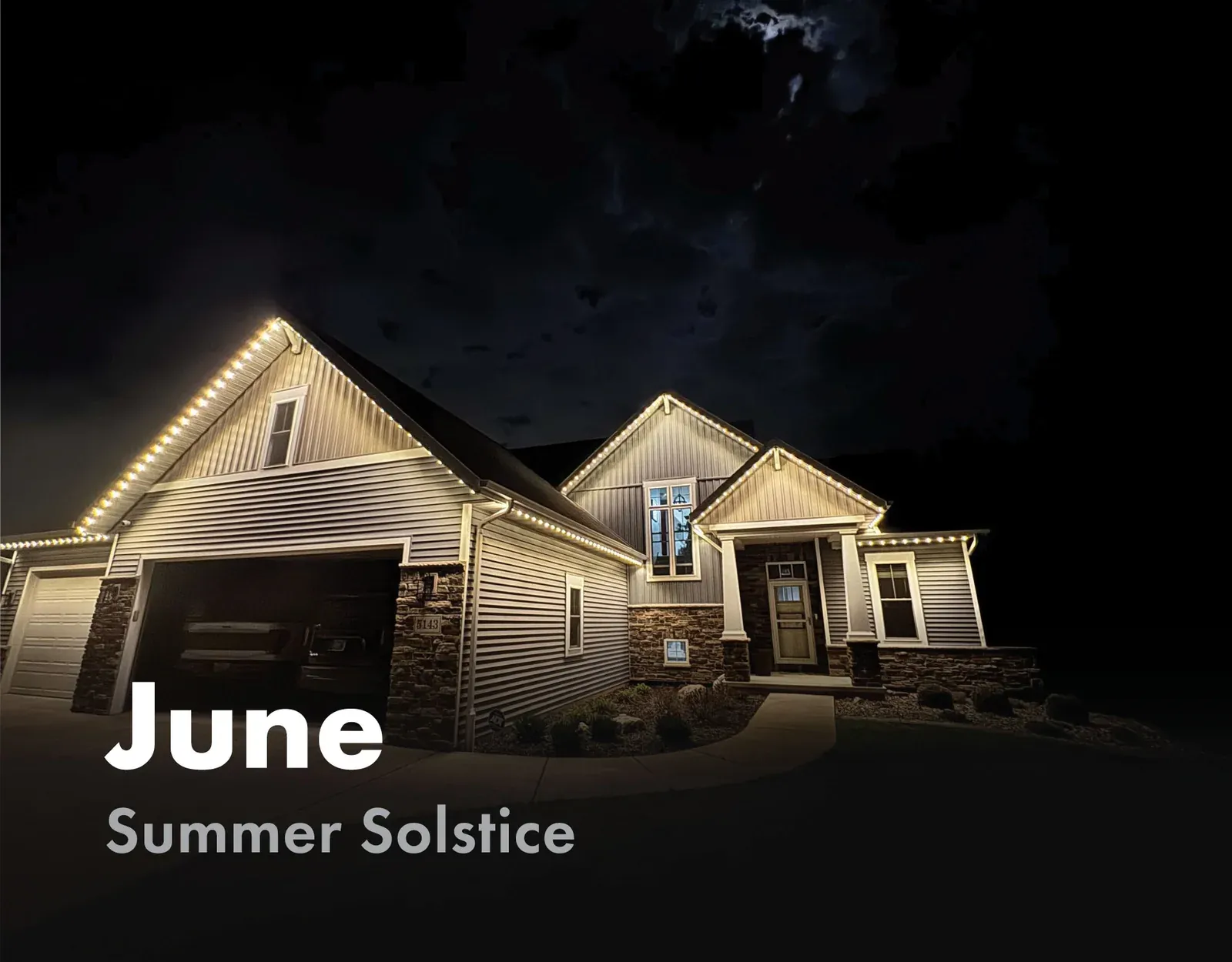 Home roofline lit in warm white for the summer solstice in June