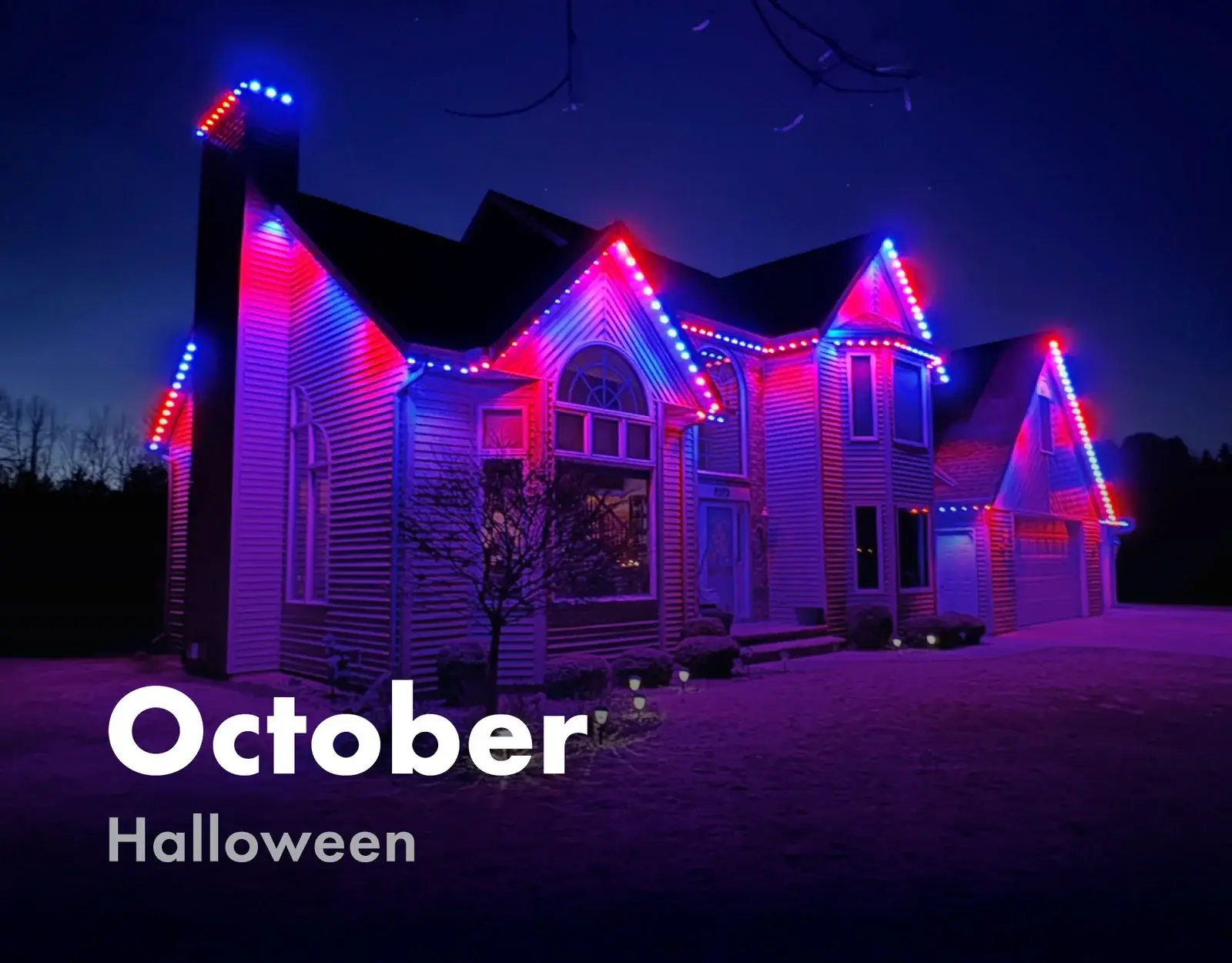Home roofline lit in orange, red and blue for Halloween in October