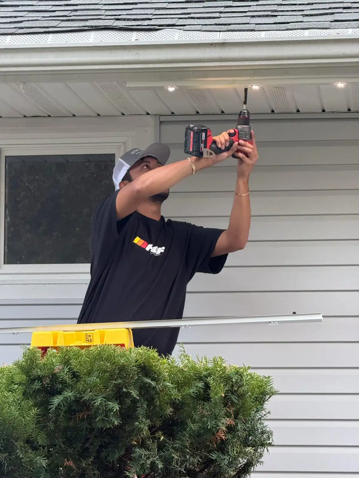 Capital Pro Lighting installer mounting permanent lighting track under a home's soffit